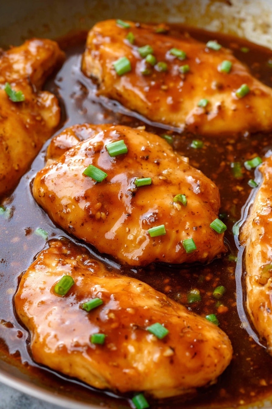 Honey Garlic Chicken - The dish shows one thick layer of light golden brown cooked chicken with a shiny, dark brown sauce on top, garnished with thin slices of green onion. The chicken sits on a bed of white rice, which is mixed with bits of the same sauce giving some parts a light brown tint. On the side, there is a small bunch of bright green, fresh green beans. Everything is arranged on a white plate over a white marbled surface, with a silver fork visible at the edge. Photo taken with an iphone --ar 2:3 --v 7