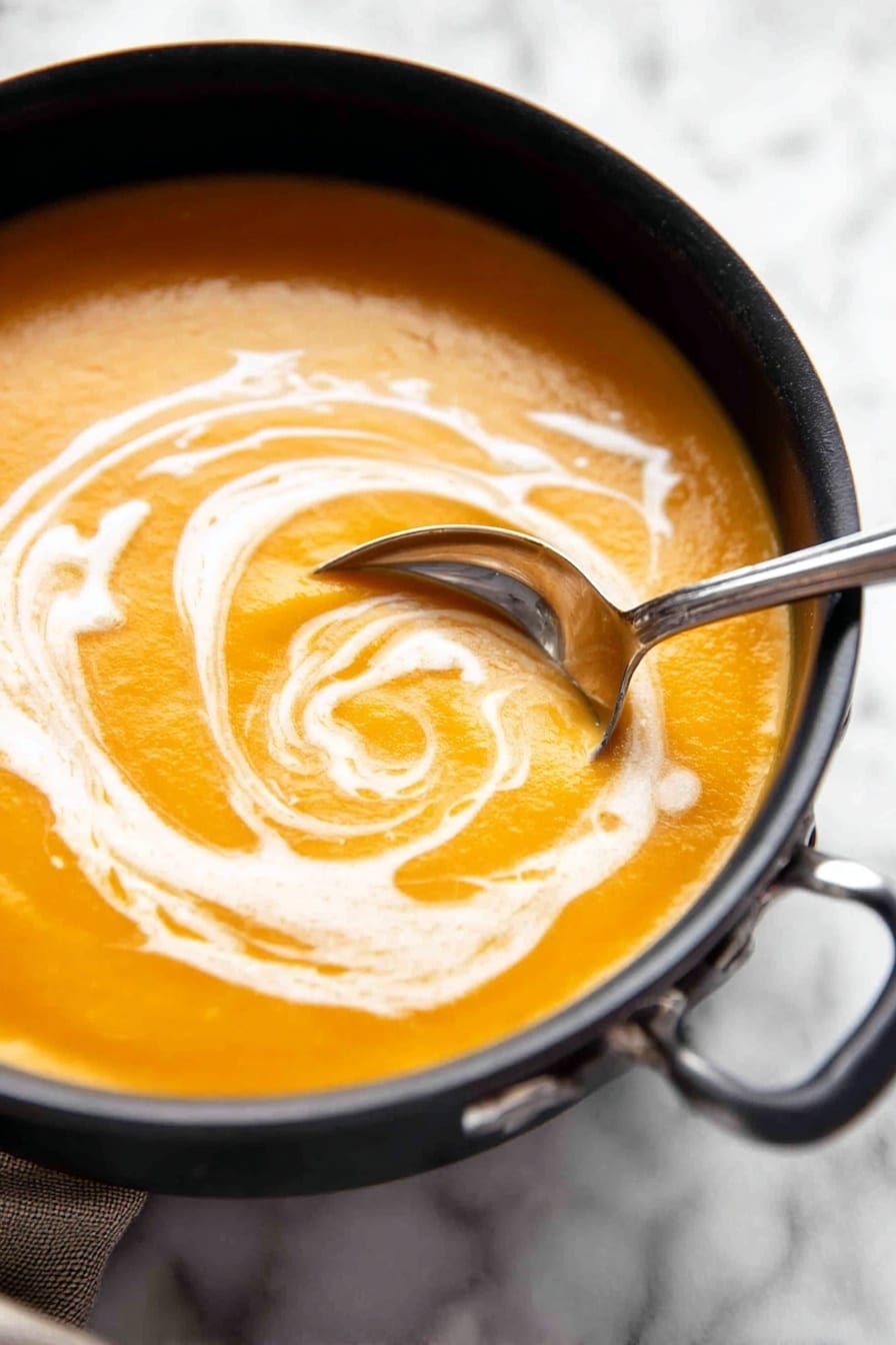 pumpkin soup - A white bowl with a blue rim is filled with smooth orange soup. On the surface of the soup, there is a swirl of white cream and a sprinkling of green herbs and black pepper, adding texture and color contrast. A woman's hand is holding a piece of white bread dipped in the soup, showing a thick layer of soup coating the bread. The scene is set against a white marbled surface. photo taken with an iphone --ar 2:3 --v 7