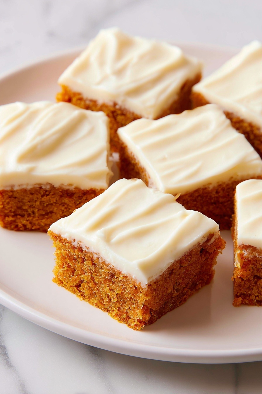 The image shows six square pieces of cake arranged on a white plate. Each piece has two layers: the bottom is a thick, moist, orange-brown cake layer with a textured crumb, and the top is a smooth, creamy, off-white frosting that covers the whole surface evenly with slight swirls. The background is a white marbled surface. The focus is soft, highlighting the creamy texture of the frosting and the crumbly texture of the cake photo taken with an iphone --ar 2:3 --v 7