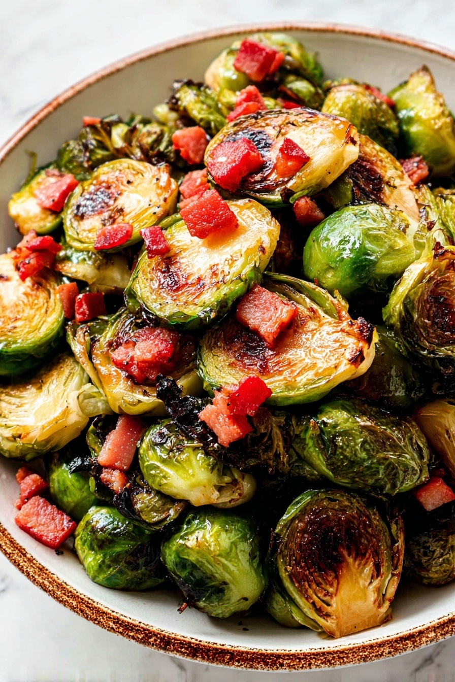 A close-up of a bowl filled with halved Brussels sprouts that are browned and caramelized on the cut sides, showing a mix of light green outer leaves and darker green inner leaves. The Brussels sprouts are layered closely together, each with a crispy texture. Scattered on top and around the sprouts are small, bright red cubes of cooked bacon, adding a pop of color and a glossy appearance from the rendered fat. The bowl is white with a rustic brown rim, and the background is a white marbled texture. photo taken with an iphone --ar 2:3 --v 7