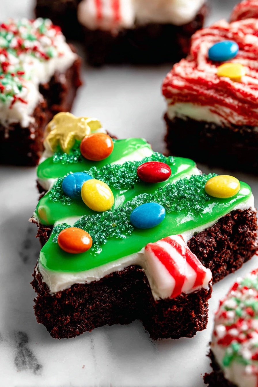 A close-up of a triangular chocolate brownie shaped like a Christmas tree with three layers: the bottom dark brown brownie layer is rough and crumbly; the middle thick white cream layer covers the brownie evenly; the top layer is bright green glossy icing shaped like a tree, decorated with colorful round candy pieces in red, blue, yellow, and orange, and sprinkled with green sugar crystals. A small red and white candy stick is placed at the tree's base to look like a trunk. The treats sit on a white marbled surface with more decorated brownies blurred in the background, some with red and white icing. Photo taken with an iphone --ar 2:3 --v 7