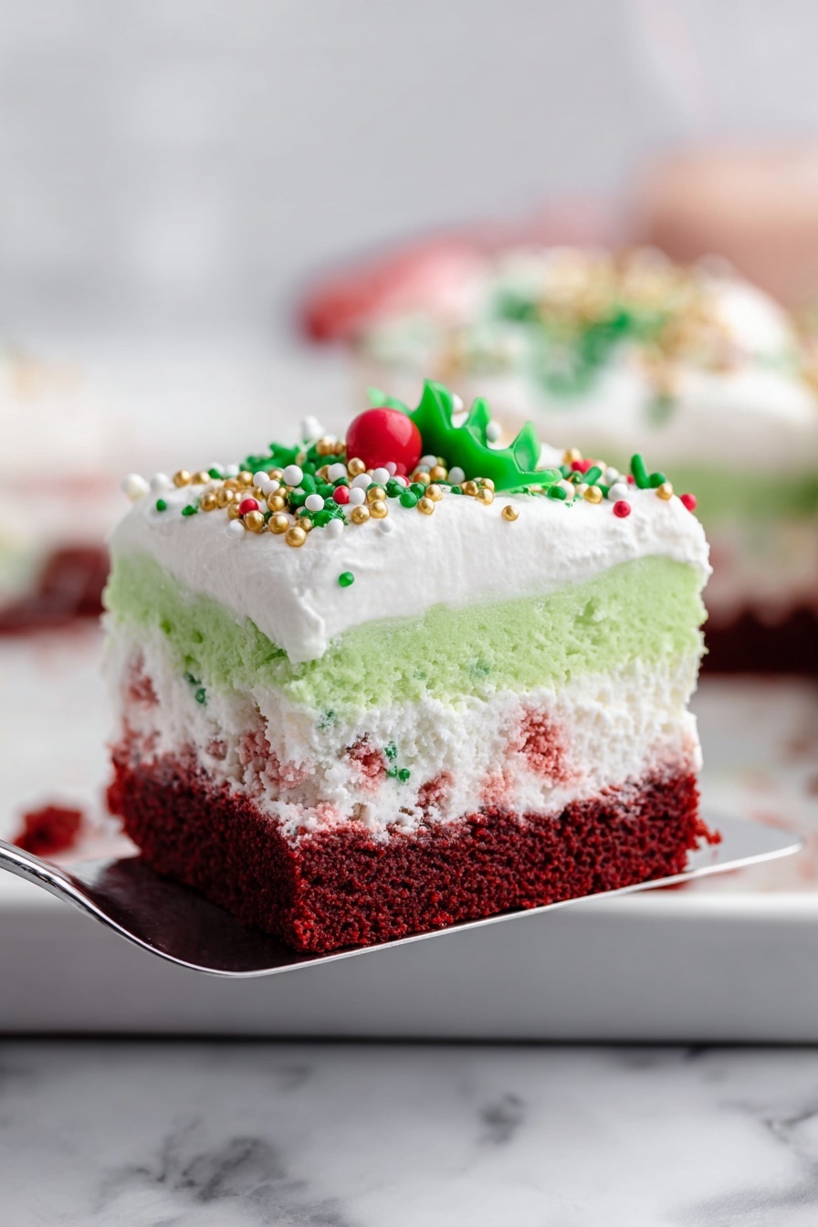 The image shows a close-up of a layered dessert square being lifted by a spatula. From bottom to top, the first layer is dark red with a soft, cake-like texture. The second layer is fluffy and white with tiny red specks mixed in. Above it is a smooth, bright green layer. The top layer is white whipped cream decorated with green, white, and gold sprinkles, including a small red round one and a green leaf-shaped sprinkle. The background features a white marbled surface and blurred objects with soft colors. photo taken with an iphone --ar 2:3 --v 7