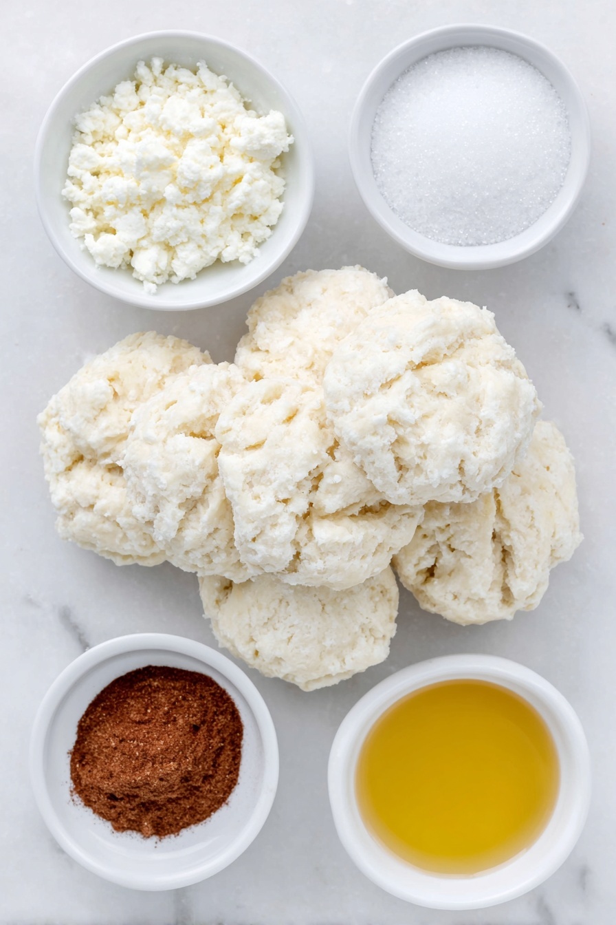 Flat lay of flaky buttermilk biscuits dough balls, a small white bowl of granulated sugar, a small white bowl of ground cinnamon, a small white bowl of melted butter, placed on a clean white marble surface, soft natural light, photo taken with an iPhone, professional food photography style, fresh ingredients, white ceramic bowls, no bottles, no duplicates, no utensils, no packaging --ar 2:3 --v 7 --p m7354615311229779997