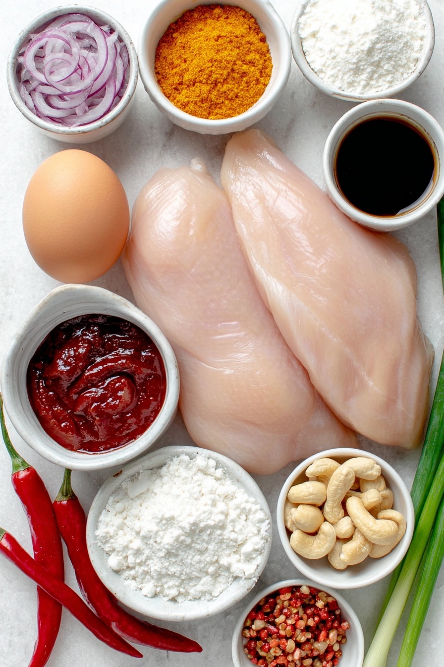 Flat lay of boneless skinless chicken breasts, one large whole uncracked egg with a clean shell, a small white bowl of low-sodium soy sauce, a small white bowl of vibrant red chili paste, a small white bowl of fresh grated ginger, a small white bowl of fresh grated garlic, a small white bowl of all-purpose flour, a small white bowl of cornstarch, a small white bowl of deep red chili powder, a small white bowl of garlic powder, a small white bowl of ground ginger, a small white bowl of black peppercorns, a small white bowl of vegetable oil, a small white bowl of unsalted raw cashews, one fresh red bell pepper sliced thinly, half a fresh red onion sliced thinly, three whole dried red chilis, a handful of whole green onions sliced on the diagonal, a small white bowl of bright red ketchup, a small white bowl of white rice vinegar, and a small white bowl of granulated sugar, all arranged with perfect symmetry and balanced proportions on a clean white marble surface, soft natural light, photo taken with an iPhone, professional food photography style, fresh ingredients, white ceramic bowls, no bottles, no duplicates, no utensils, no packaging --ar 2:3 --v 7 --p m7354615311229779997