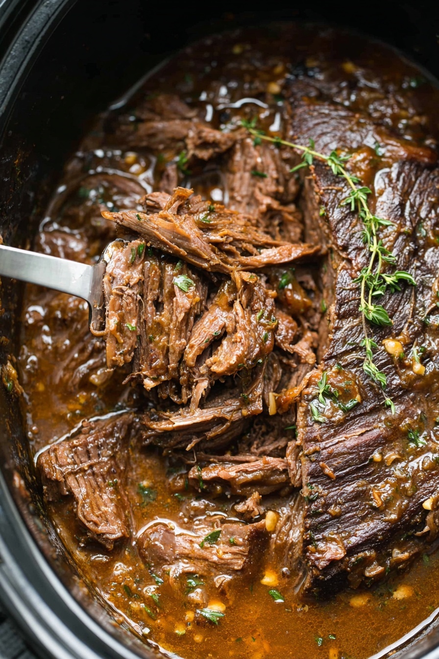 A close-up of a large piece of cooked beef in a black pot, with part of the meat shredded on one side showing soft, moist texture and darker brown seared edges. The meat is covered in a thick brown sauce with visible herbs like thyme scattered on top and around. A metal fork is lifting some shredded meat, with the handle resting at the bottom edge of the image. The sauce looks rich and glossy, pooling around the meat inside the pot. The background is a white marbled texture photo taken with an iphone --ar 2:3 --v 7